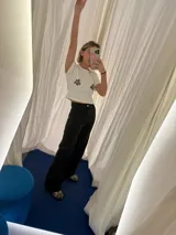 Jean negro de corte wide leg, con tiro alto y bolsillos laterales.