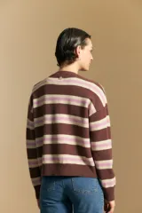 Cardigan de punto con diseño de rayas horizontales en tonos marrón, rosa y beige. Presenta cuello redondo, cierre frontal con botones y mangas largas con puños acanalados.