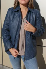 Campera de cuero azul con acabado gastado, diseño acolchado con costuras en forma de rombos, cierre frontal completo y bolsillos laterales.
