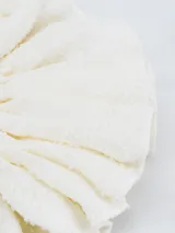 Colero de tela color crudo con textura arrugada.