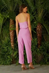 Pantalón de vestir rosado con corte recto, tiro alto y detalle de cadena dorada en la cintura.