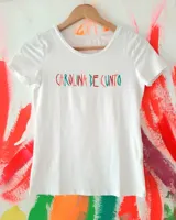 Remera blanca de manga corta con cuello redondo, confeccionada con estampado frontal multicolor con la inscripción "Carolina De Cunto".