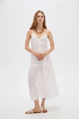 Vestido midi blanco de algodón con diseño broderie, tirantes finos, escote en V y cierre frontal con botones.