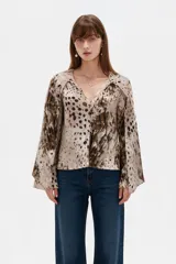 Blusa de poliéster de corte holgado con cuello en V, mangas largas acampanadas y estampado abstracto multicolor en tonos marrones y beige.