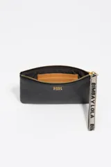 Monedero grande de piel vacuna color rojo, con cierre superior y correa de muñeca de tela con el logo de la marca. Incluye el logo metálico dorado en el frente.