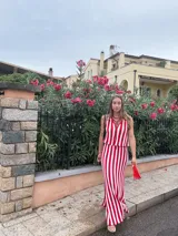 Falda larga tejida a rayas verticales rojas y blancas, con pretina elástica y tajos laterales.