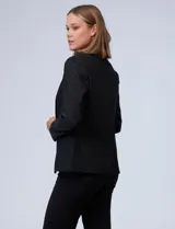 Blazer negro de tejido elastizado con pequeños puntos brillantes de lurex, cuello con solapa y un solo botón frontal.