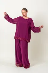 Blusa italiana de gasa color fucsia, con escote redondo y mangas largas acampanadas. Presenta apliques de lentejuelas al tono en el ruedo y los puños.