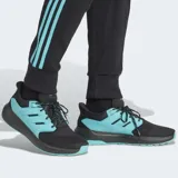 Pantalón de jogging Adidas Mercedes AMG Petronas Formula One Team DNA, color negro con tres tiras turquesas a los costados y logo estampado en la pierna.