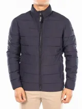 Campera puffer azul marino con cierre frontal, cuello alto y bolsillos laterales con cierre. Logo de Calvin Klein en la manga.