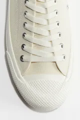 Championes de lona color crema con cordones y suela de goma.