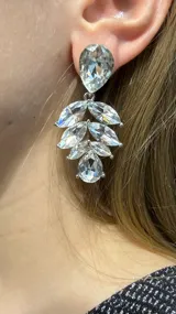 Caravana colgante de diseño floral compuesta por múltiples cristales transparentes en forma de gota y marquise, montados sobre una base metálica plateada.