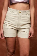 Shorts de tiro alto y corte recto, confeccionados en cuero. Diseño con bolsillos laterales y traseros, pasadores para cinturón y cierre frontal con botón.