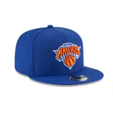 Gorro New Era azul con visera plana, logo de los New York Knicks bordado en el frente y cierre snapback ajustable.
