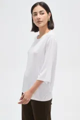 Remera de viscosa en color verde oliva, con cuello redondo y mangas 3/4. Presenta un diseño de tejido acanalado y corte holgado.