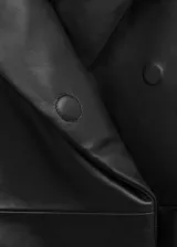 Chaqueta bomber oversize de cuero negro con cuello alto envolvente, manga larga y cierre delantero oculto.