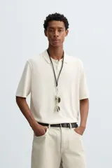 Polo de punto de corte regular fit, confeccionado en una mezcla de algodón y lyocell. Presenta cuello de solapa con cierre frontal de botones, manga corta y acabados en rib en puños y bajo.
