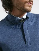 Sweater de punto color tostado, con cuello alto y cierre frontal parcial con botones. Diseño de manga larga con puños y ruedo acanalados.