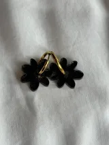 Aros de argolla metálica con dije colgante en forma de flor de acrílico color rosado.