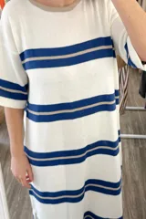 Vestido largo tejido a rayas horizontales azules y beige sobre fondo blanco, con mangas cortas y tajos laterales.