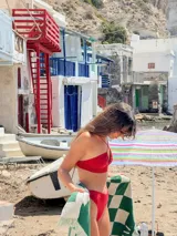 Top de hilo negro con tirantes finos cruzados en el frente y abertura circular en el centro.