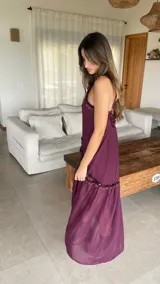 Vestido largo color bordó con escote halter y detalles de volados diagonales.