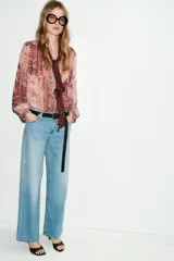 Jeans de tiro bajo color azul claro, con cinco bolsillos y pernera ancha. Cierre frontal con cremallera y botón.