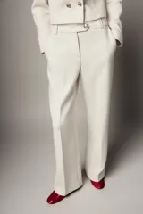 Pantalón de tiro alto con pernera recta y raya planchada en el delantero. Cuenta con bolsillos laterales y cierre frontal con cremallera y botón.
