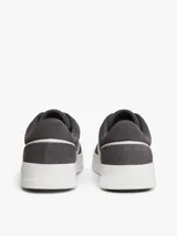 Zapatillas de tenis Tommy Hilfiger de corte bajo, confeccionadas en ante color gris con paneles en contraste de color blanco. Presentan cierre con cordones, suela de goma blanca y logo de la marca grabado en el lateral y el talón.