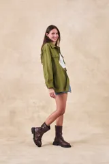 Sobrecamisa verde militar de lino y viscosa, corte oversize, con cuello camisero, cierre frontal con botones, mangas largas con puños abotonados, dos bolsillos de parche con solapa en el pecho y ruedo recto.