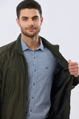 Campera liviana de nylon color azul marino, con cuello alto, cierre frontal y puños y dobladillo en elástico tejido.