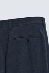 Pantalón de traje corte slim fit, color azul marino con textura sutil. Cuenta con bolsillos laterales, bolsillos traseros con botón y cierre frontal con cremallera y botón.