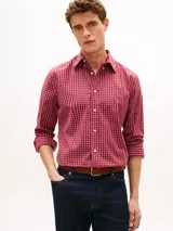 Camisa de corte regular de Tommy Hilfiger, confeccionada en popelín de puro algodón con acabado aterciopelado y diseño de cuadros en tonos rojos y blancos. Presenta cuello clásico abotonado, mangas largas con puños redondeados y el logo bordado en el pecho.