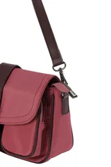 Bandolera urbana de diseño compacto, color negro, con solapa frontal decorada con una hebilla central, bolsillos frontales y correa ajustable para llevar al hombro o cruzada.