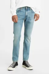 Jean Levi's modelo 512 Slim Taper, de corte ajustado y pierna cónica, en tono azul medio claro con efecto desgastado. Cuenta con cierre de botones y diseño clásico de cinco bolsillos.