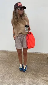 Bandolera grande de nylon reciclado color coral neón, con cierre de cordón ajustable y correa larga regulable.