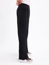 Pantalon de felpa negro de corte recto y holgado, con cintura elástica y cordón ajustable.