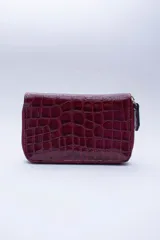 Billetera chica con cierre exterior, bolsillo para monedas con cierre en la parte trasera, múltiples ranuras para tarjetas y billetes. Confeccionada en cuero con forro rojo.