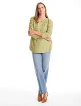 Blusa de silueta fluida en tejido shaggy con textura de franjas horizontales. Presenta cuello a la base, mangas tres cuartos con tajo lateral en el puño y ruedo redondeado con corte asimétrico, siendo más largo en la parte posterior.