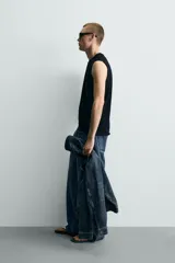 Camiseta tank de punto de algodón, color negro, de corte relaxed fit con cuello redondo, manga sisa y acabados irregulares.