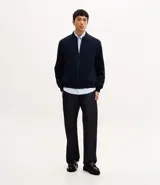 Campera tipo bomber color beige, con cierre frontal de cremallera, cuello estilo béisbol, puños y ruedo acanalados. Cuenta con bolsillos laterales con cierre y tecnología repelente al agua.