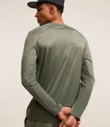 Remera deportiva de manga larga con cuello redondo, confeccionada en tejido técnico Dry Fit. Presenta un diseño liso en color negro con detalles reflectantes en los hombros.