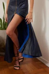 Vestido largo azul con efecto tie-dye, confeccionado en cuero vintage con accesorios dorados. Presenta cierre frontal con cremallera dorada que se extiende hasta el ruedo, y abertura en la pierna.