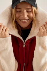 Chaleco puffer rojo con cuello de sherpa color crema, cierre frontal con cremallera y bolsillos laterales.