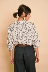 Camisa blanca de manga larga con cuello mao y estampado de motivos vegetales en tono azul oscuro.