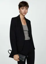 Blazer negro de corte recto y estilo sastre, con cuello de solapa con muesca, cierre frontal de un botón, mangas largas con puños abotonados y dos bolsillos delanteros con solapa.