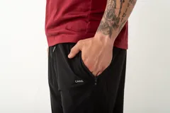 Pantalón deportivo de corte recto y ajuste cómodo, confeccionado en tejido ligero con acabado técnico. Presenta bolsillos laterales con cierre y un pequeño logo bordado en la parte superior.