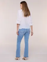 Blusa blanca de manga larga con escote en V y detalles de encaje en la botonera frontal, cuello y puños.