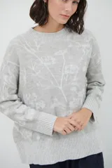 Buzo de tejido de punto con cuello redondo, mangas largas con puños acanalados y diseño estampado de flores en tonos rojos.