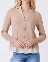 Buzo de punto fino color beige con diseño de camisa incorporada. Presenta escote en V con cierre frontal de botones, mangas largas con puños acanalados y cuello y ruedo con estampado de rayas verticales que simulan una camisa debajo.